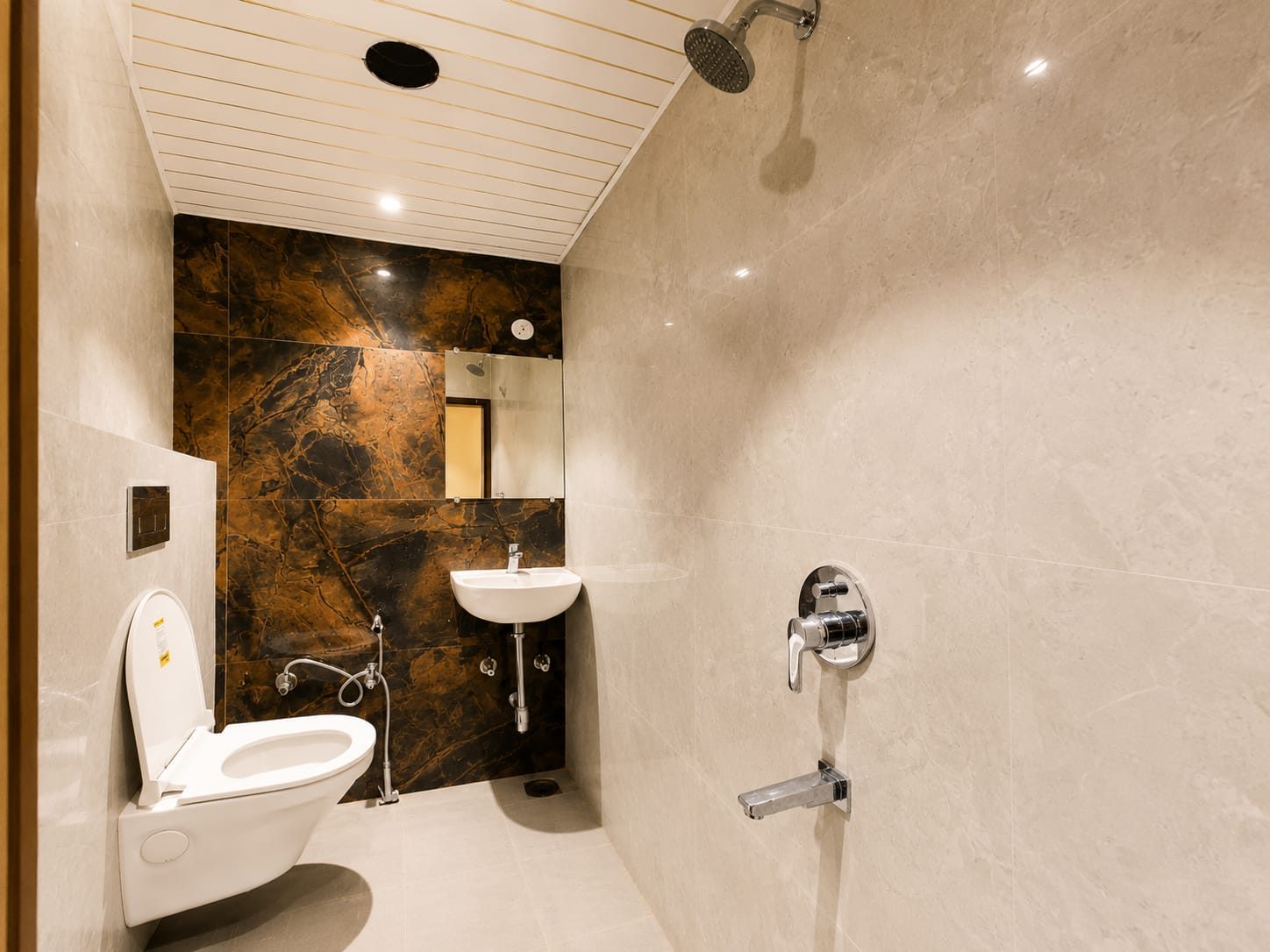 Bathroom finished in stone-look tile with a rain shower