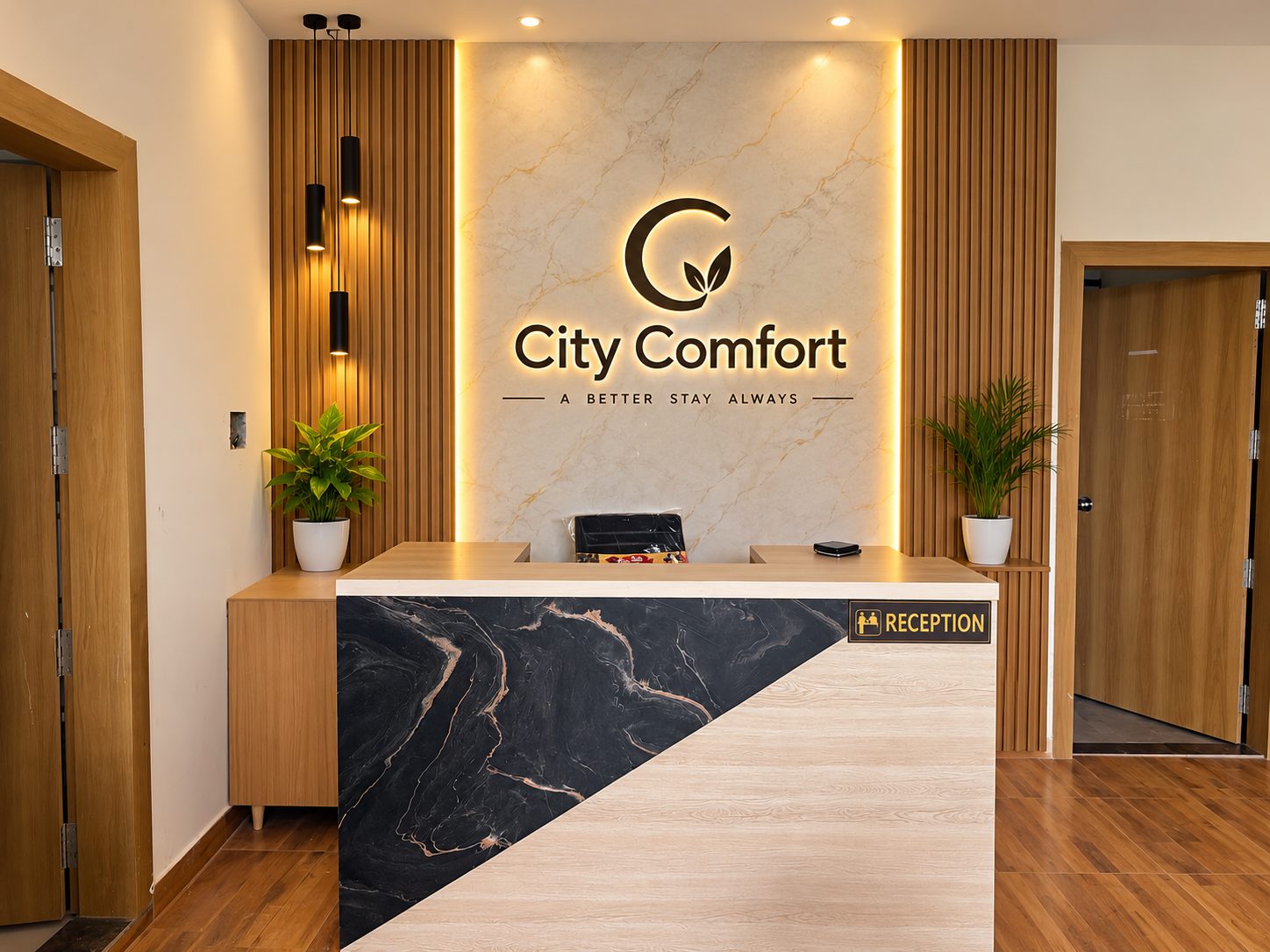 The reception at City Comfort Hotel — a black-and-gold marble desk under the backlit City Comfort sign